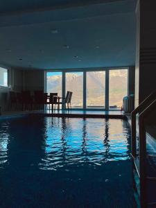 - une piscine avec une table et des chaises dans un bâtiment dans l'établissement Villa SHAMS, à Travnik