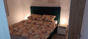 a small bedroom with a bed with a green headboard at Villa SHAMS in Travnik +20 photos