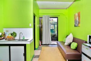 eine Küche mit grünen Wänden, einem Sofa und einem Waschbecken in der Unterkunft Golden V Executive Homes Unit I in Malolos