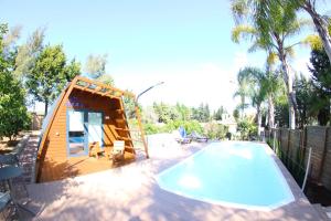 a tiny house next to a swimming pool at Fazenda Viegas in Lagos