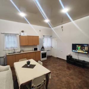 Habitación con mesa y cocina con TV. en LANJ IN Eco Garden/ Guest House, en Nurrnus