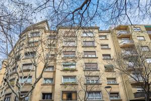 ein hohes Gebäude mit vielen Fenstern und Bäumen in der Unterkunft BBarcelona Gaudí Avenue Flat in Barcelona