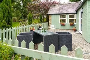 a backyard with a white fence and a table at Penbontbren Luxury Bed and Breakfast in Aberporth