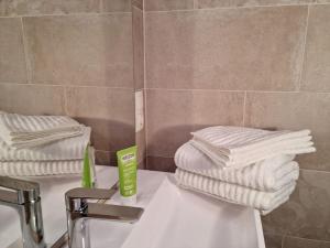 a bathroom with two stacks of towels on a sink at Cottage1 in Nature Resort Swimming Pond Pool Sauna in Kiskunmajsa