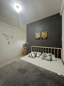 una camera da letto con un grande letto con due cuscini di D'Flora Homestay a Labuan Bajo