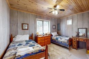 1 Schlafzimmer mit 2 Betten und einem Deckenventilator in der Unterkunft Snowbird Family Retreat in Beech Mountain