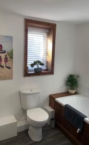 a bathroom with a white toilet and a bath tub at The Home Away From Home in Great Harwood