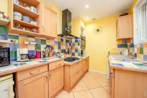 a kitchen with wooden cabinets and colorful tiles on the walls at La Casa-li-re - Jardin & Confort à Albi in Albi +26 photos