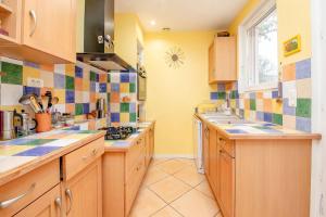a kitchen with wooden cabinets and colorful tiles on the wall at La Casa-li-re - Jardin & Confort à Albi in Albi