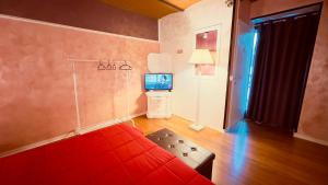 sala de estar con sofá rojo y TV en Castelpetroso Bed&Breakfast, en Castelpetroso