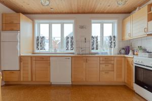 a kitchen with wooden cabinets and white appliances at The Cookie Store Guesthouse in Tórshavn