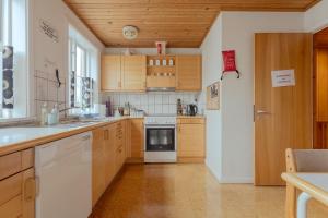 a kitchen with wooden cabinets and a white stove top oven at The Cookie Store Guesthouse in Tórshavn