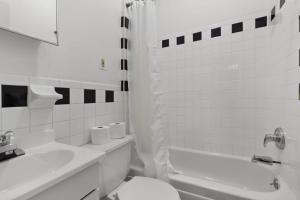 ein weißes Bad mit einem WC und einem Waschbecken in der Unterkunft Cozy 1BR in the Upper East Side in New York