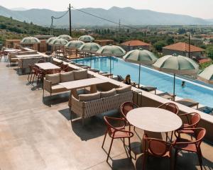 a hotel patio with tables and chairs and a pool at AKROTHEA suites & lounge in Tripoli