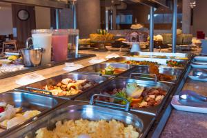um buffet com muitas bandejas de comida numa mesa em Sotero Hotel by Castelo Itaipava em Salvador