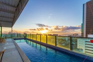 una piscina en la azotea de un edificio con puesta de sol en Sotero Hotel by Castelo Itaipava, en Salvador