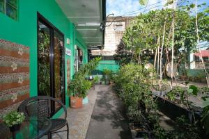 een groen gebouw met een patio met potplanten bij Golden V Executive Homes Unit J in Malolos