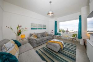 a living room with a couch and a table at Absolute Beachfront with Decked Garden Oasis and Views in Bognor Regis