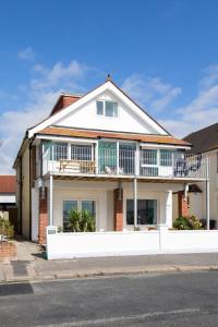 a house with a balcony on top of it at Absolute Beachfront with Decked Garden Oasis and Views in Bognor Regis