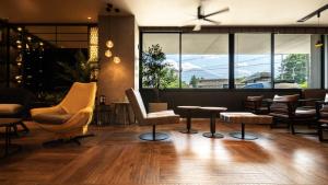 a lobby with chairs and tables and a large window at Super Hotel Fujikawaguchiko Tennenonsen in Fujikawaguchiko