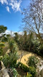 a pool of water in a garden with trees at LE MIDOU - Vue Rivière in Mont-de-Marsan