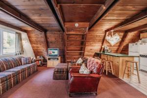uma sala de estar com um sofá e uma cozinha em 54SL - Hot Tub - Pets OK - Sleeps 4 cabin em Glacier