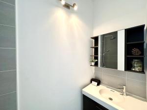 La salle de bains est pourvue d'un lavabo et d'un miroir. dans l'établissement LE MIDOU - Vue Rivière, à Mont-de-Marsan