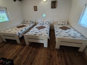 - 2 lits dans une chambre dotée de parquet dans l'établissement Kuca Delić, à Račić