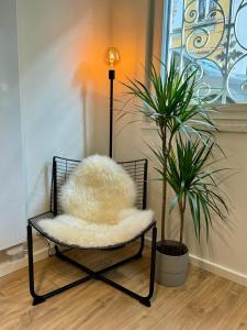 a chair with a furry pillow in a room with a plant at J1 - Urban studio in Antwerp in Antwerp
