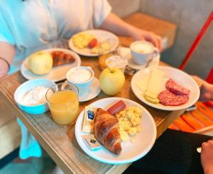 - une table avec des assiettes de produits pour le petit-déjeuner et des boissons dans l'établissement Ostello Bello Lake Como, à Côme