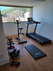 una habitación con gimnasio con cinta de correr y pesas en Leblon Inn, Ótimo Ap en Río de Janeiro