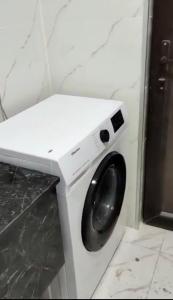 a white washing machine sitting in a bathroom at Almare Batumi in Batumi