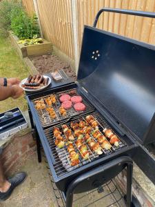 a grill with burgers and other food on it at Beautiful Period Victorian Home Quirky & Charming in Handforth