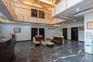 een lobby met banken en stoelen in een gebouw bij Saavi Hotel Huda City Centre in Gurgaon