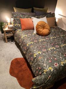una camera da letto con un letto con un piumone e cuscini di Beautiful Period Victorian Home Quirky & Charming a Handforth
