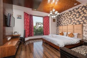 een slaapkamer met een bed, een tv en een raam bij Saavi Hotel Huda City Centre in Gurgaon
