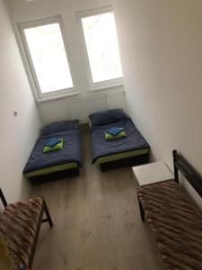 two beds in a small room with two windows at Easy Backpacker Old Town in Košice