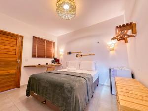 a small bedroom with a bed and a table at Pousada Amazing Jeri in Jericoacoara