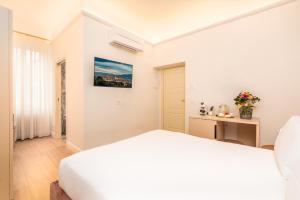 a white bedroom with a bed and a table at Hotel Ginori Al Duomo in Florence