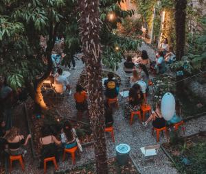 een groep mensen die in stoelen in een tuin zitten bij Ostello Bello Lake Como in Como