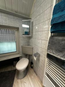 uma casa de banho com um WC, uma janela e toalhas azuis em FewoVolmetal em Meinerzhagen