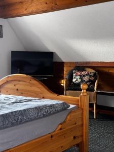um quarto com uma cama de madeira e uma cadeira em FewoVolmetal em Meinerzhagen