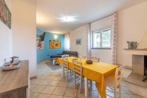 - une salle à manger et un salon avec une table et des chaises jaunes dans l'établissement Villa Estro del Sud, à Gagliano del Capo