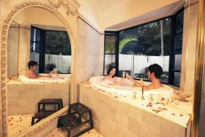 un groupe de personnes dans une baignoire dans une salle de bains dans l'établissement Escarpment Retreat & Day Spa for Couples, à Mount Tamborine