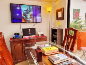 uma sala de estar com uma mesa e uma televisão na parede em Living Club em Guatavita