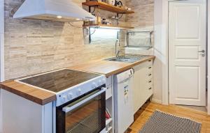 cocina con fregadero y fogones en Awesome Home In Tvrred With Wifi And 3 Bedrooms, en Alhammar
