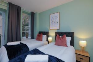 two beds in a room with blue walls at Wonderful Apartment in Bath wGarden - Sleeps 8 in Bath