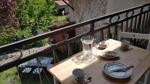 a wooden table with plates and glasses on a balcony at Gîte Valentine in Aubin
