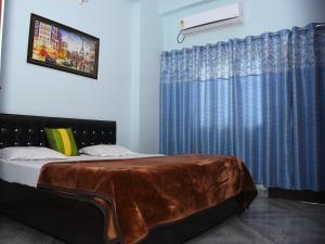 um quarto com uma cama com uma cortina azul em Indra Apartment em Varanasi