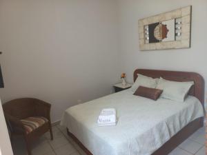 een kleine slaapkamer met een bed en een stoel bij Suites Casa Maia in Capitólio